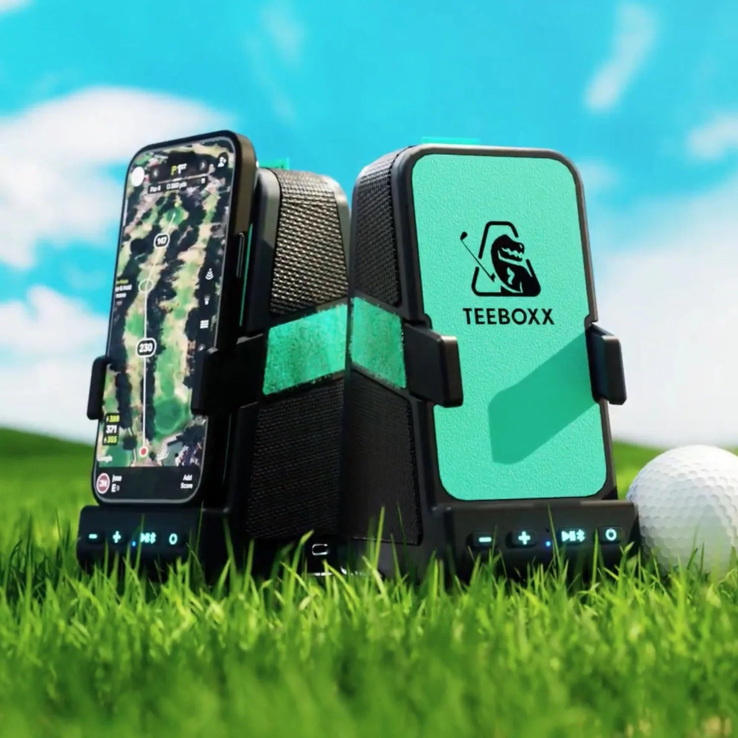 Two TeeBoxx units on the grass next to a golf ball, one holding a phone with a golf map